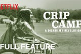 Promotional photo for Netflix’s Crip Camp — a person in a wheelchair with long hair, smiling