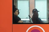 A woman looking out the window while riding on a public city bus