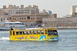A yellow bus in the water.