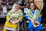 Zarghoona Wadood, Joshua Dilawer and Afsha Afridi, from PAN, smile at the camera together in the main auditorium at ARJC 2024.