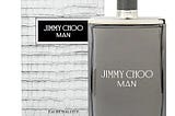 A luxurious bottle of Jimmy Choo perfume featuring a diamond-shaped design with a gold cap, set against a soft white background. The elegant packaging exudes sophistication and glamour, reflecting the high-end nature of the fragrance.