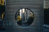 ambreen-hasan-unsplash-min.jpg a city view through a circular sculpture