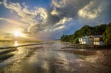 house on the beach, with a sunset