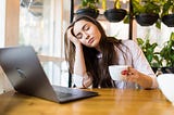 Young woman professional is stressed in front of her laptop