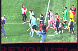 MLS referee crew, Carles Gil of New England Revolution, and Lionel Messi, the greatest soccer player on the planet, taking the field at Gillette Stadium on April 27, 2024. Gil in the Revs blue kits with red accents, Messi in the Inter Miami pink kit.