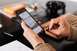 Crop woman using smartphone at table