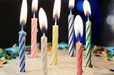 seven lit candles on a birthday cake