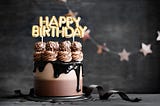 Chocolate birthday cake with chocolate ganache drip icing and happy birthday banner