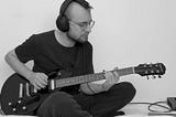 Author playing guitar with headphones.