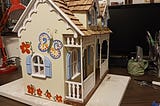 dollhouse with butterflies and flowers on the siding.