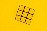 A Yellow Rubik's Cube. Or a side of Rubik's cube that is all yellow. The background is yellow too. It is not a real image. An illutration.
