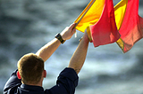 A sailor communicating with semaphore flags