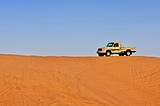 A lone truck on top of the red sand dunes of Riyadh, Saudi Arabia