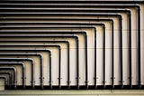 Pipes on a wall form geometric shapes.