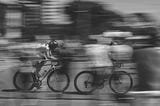 A black and white photo with blur of movement showing speed, racing, fast past. pursuit. Momentum.
