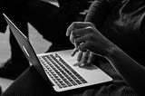 Lady pressing the trackpad of an Apple mac