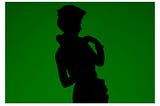 A landscape silhouette of a porcelain doll on a dark green background