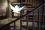 A cartoon bird flies upward in a photo of a loft with a spiral staircase. Cartoon and photo by Doodleslice 2024.