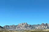 Photo by the Author. Blue sky, and the road between the mountains of Nevada
