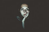 Woman sitting in the dark lit by a screen