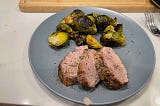 Pork tenderloin medallions and brussels sprouts, plated.