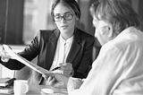 black and white image of female adviser consulting with elder client