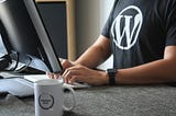 A person wearing WordPress t-shirt is working in front of the computer