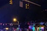 a screenshot from June 24, 2020, shows CPD in riot gear and in formation in front of the Ohio Statehouse, lit up in rainbow colors for Pride Month. Text at the top of the photo reads: broadcast interrupted.
