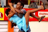 A man lifts a woman off the ground during a dance of Forró