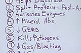 A note on a piece of paper listing items: “Helps Digestion, Split Protein, Activates Enzymes, Mineral Abs, GERD, Kills Pathogens, Gas/Bloating”