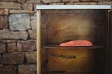 Side of salmon on shelf in outdoor cold smoker