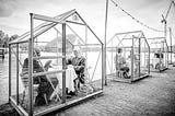 Guests of ETEN sitting inside greenhouses that the restaurant has converted into isolated dinning pods.