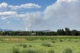 Field and mountains with fire plume from Alexander Mountain Fire on Monday, July 29, 2024. Photo by the author