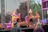 A band plays on a stage while people watch.
