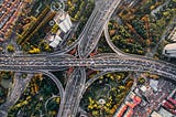 A busy traffic intersection from bird’s eye view, surrounded by trees