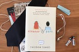 the book eleanor and park is sitting on a table with earbuds strung across