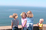 Four young children looking at an ocean view