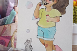 ilustração de uma menina soltando bolinhas de sabão e um gatinho tentando pegar as bolinhas.