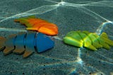 Three fish toys sitting on the bottom of the pool