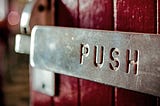 A sign on a door that says “Push”