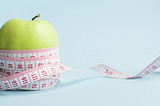 An apple wrapped with a measuring tape