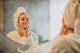 Skin care in the morning woman applying cream mask