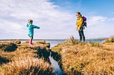 Mother and daughter separated by a narrow creek