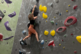 Woman rock climbing at a bouldering gym