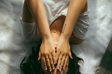 A photo of a woman lying on her back, covering her eyes. This image captures the sense of overwhelm that can arise from distraction. By practicing mindfulness and sharpening our focus, we can enhance our work, relationships, and overall well-being.