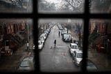 A pedestrian walks a dog through a quiet street in New York on March 17.