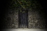 Photo of a wooden door in a stone wall.