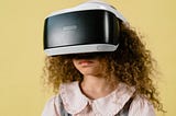 a young girl with curly hair wearing a VR headset