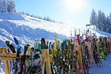 A row of skis propped up in the snow