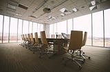 Chairs surround a table in a board room.